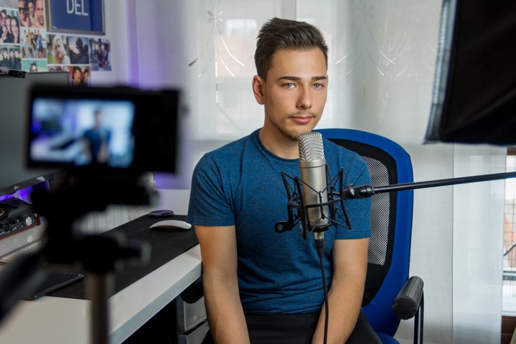 A person sitting and speaking their answers aloud into a microphone, building interview practice before the real conversation.