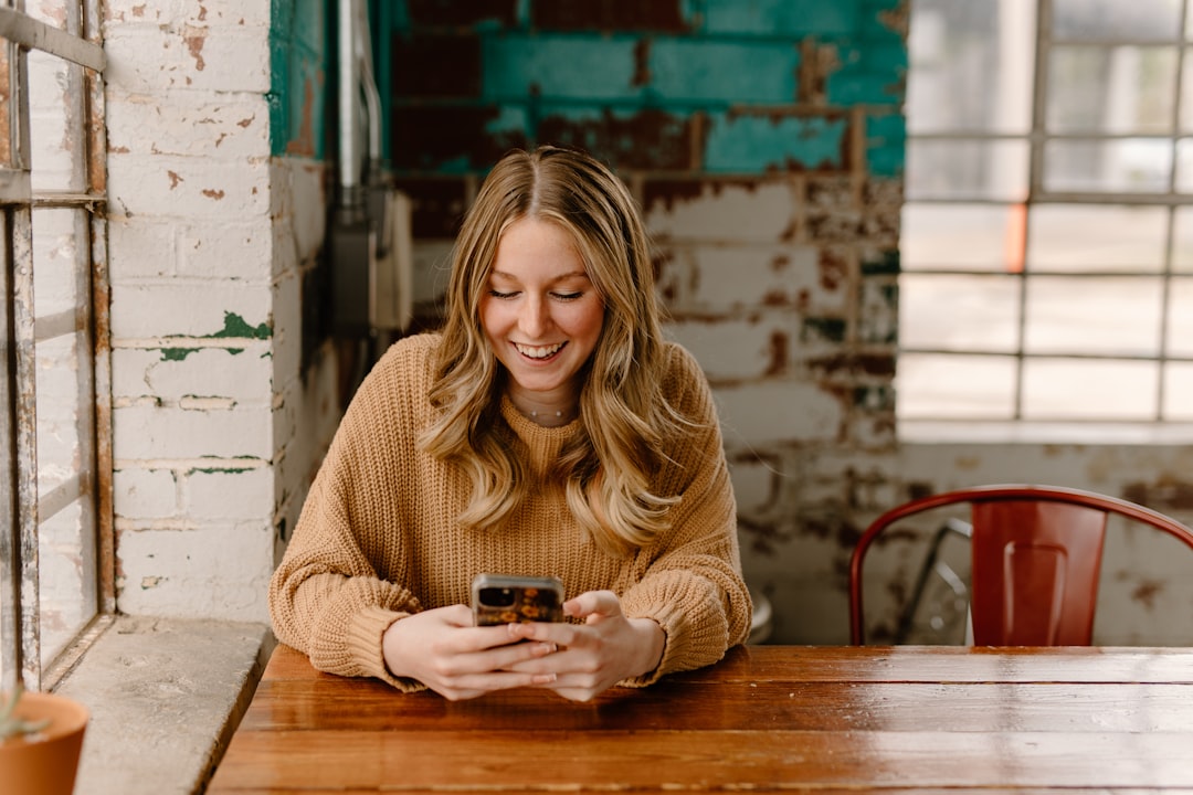 A job seeker checking her phone after sharpening her LinkedIn profile, the moment an inbound recruiter message arrives.