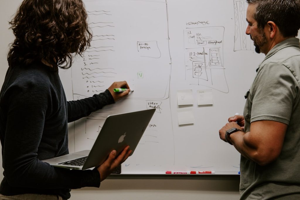 Product manager presenting strategy at a dry-erase board to lead the team toward outcomes