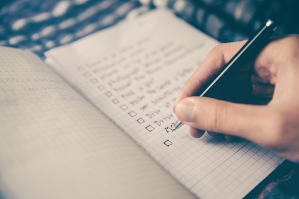 A person sitting at a desk writing by hand in a notebook, focused and deliberate, illustrating the intentional effort a strong cover letter requires.