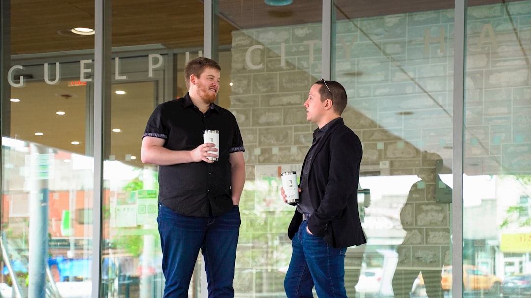 Two professionals talking outside an office building, the kind of off-the-record conversation that produces honest company research about a role.