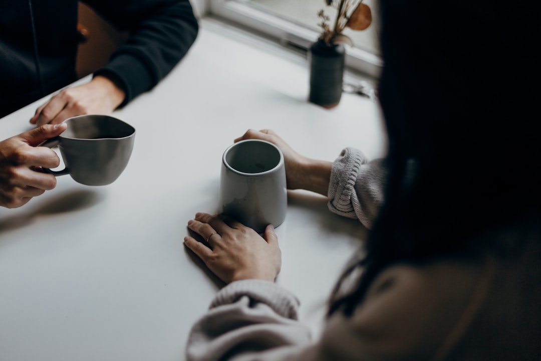 Two people having a one-on-one coffee conversation at a table, representing the warm conversation a reverse job search creates.
