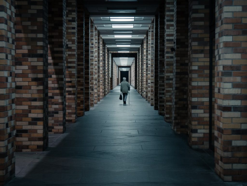 A person walking alone down a long empty hallway toward the exit, illustrating the decision to step away from an unreasonable interview process.