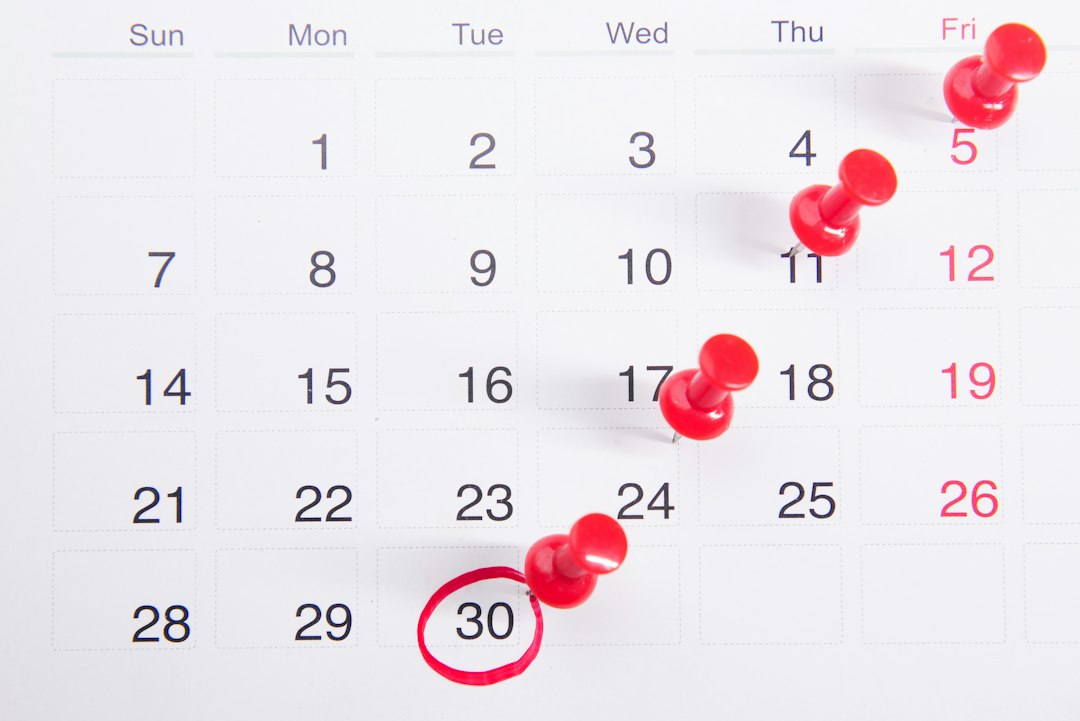 Paper calendar with red push pins marking one date each week, stepping down to a final date circled in red