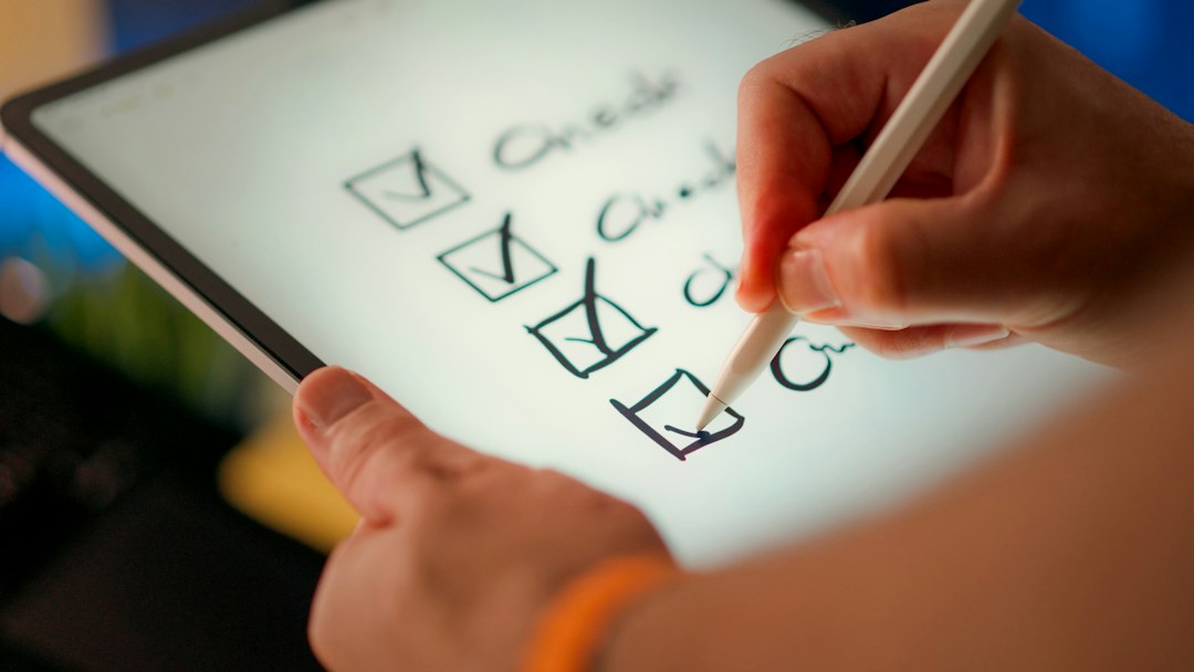 Hand using a stylus to tick four checkboxes on a checklist drawn on a tablet screen